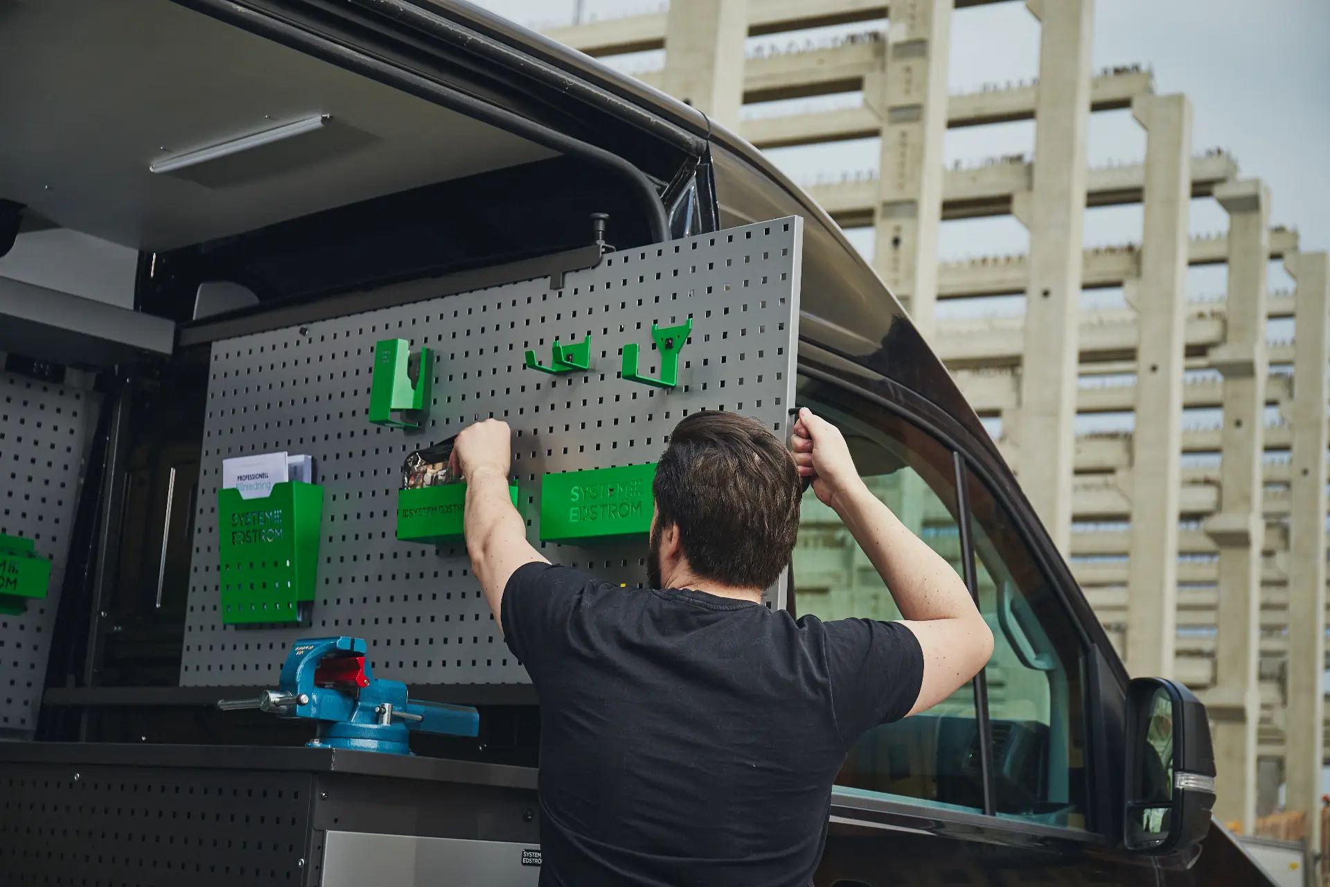 Techniker montiert Halterungen an der Lochwand eines VW Crafter